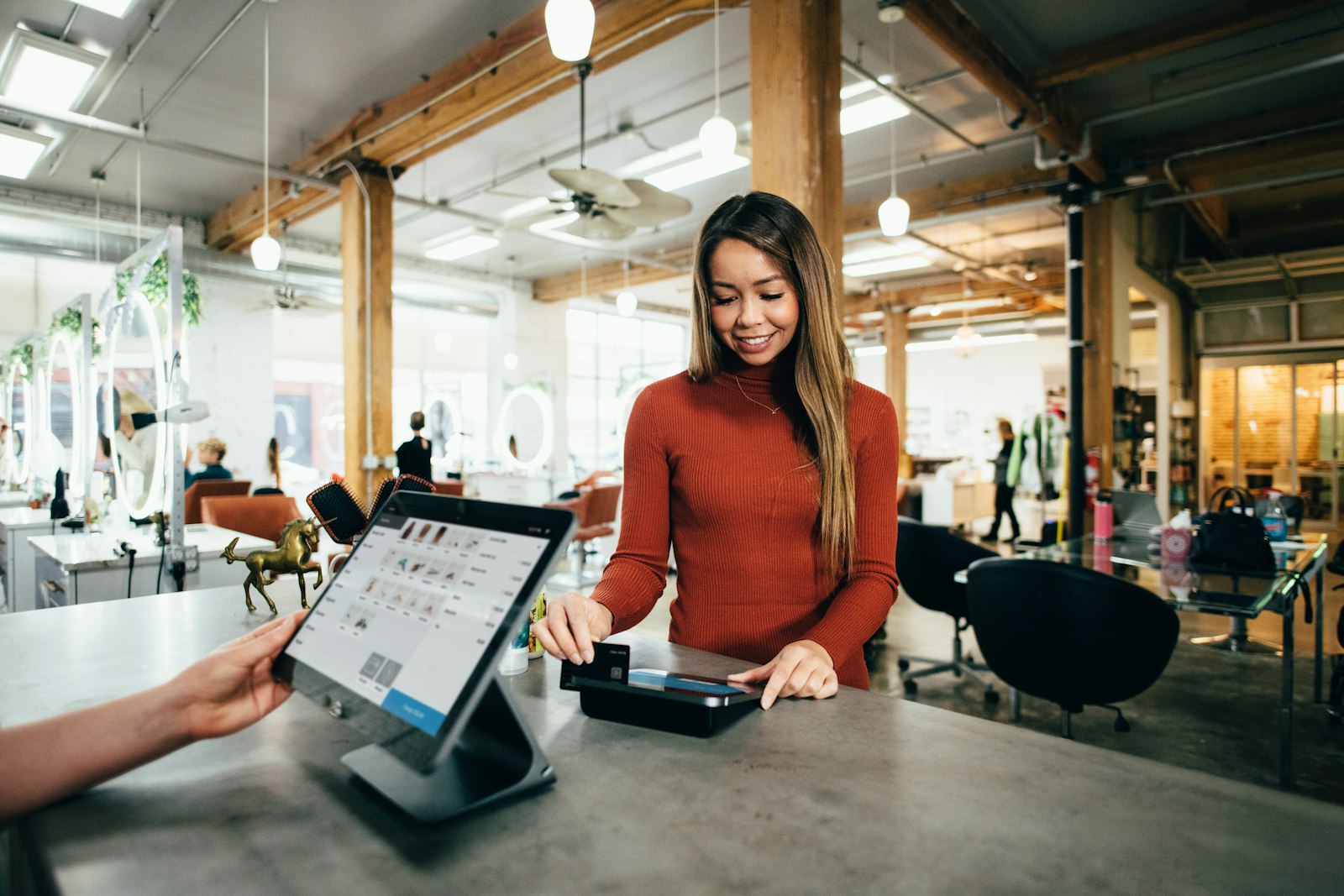 A customer paying at a salon front counter