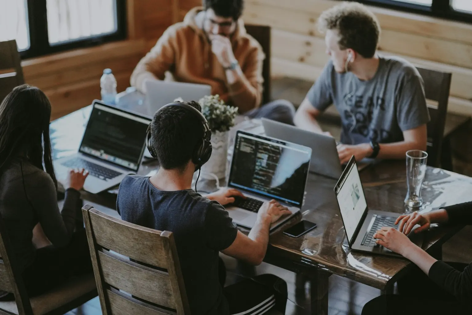 A team working across laptops at a shared table